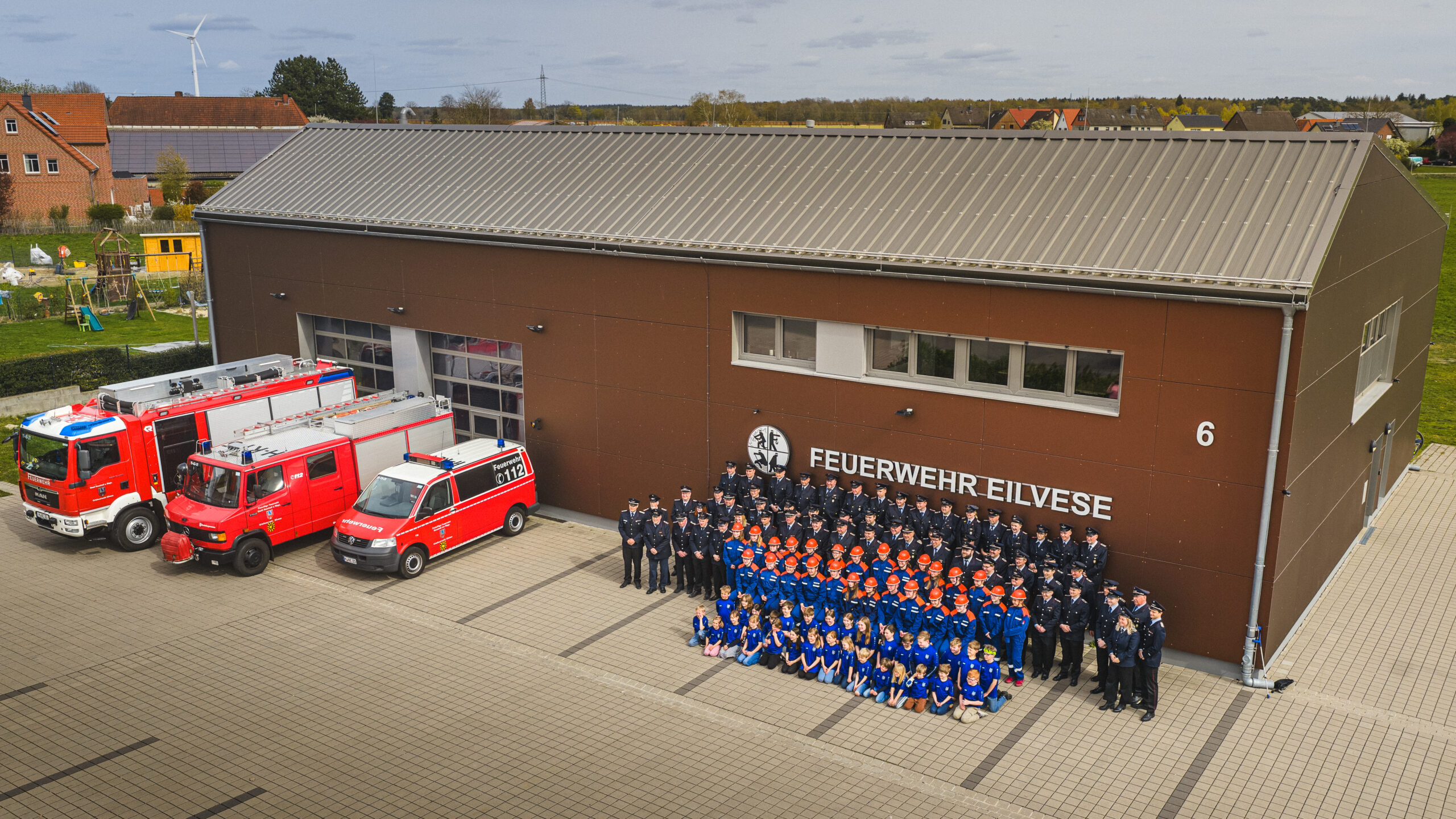 Luftaufnahme des Feuerwehrhauses Eilvese mit allen drei Einsatzfahrzeugen und den vier Abteilungen der Wehr