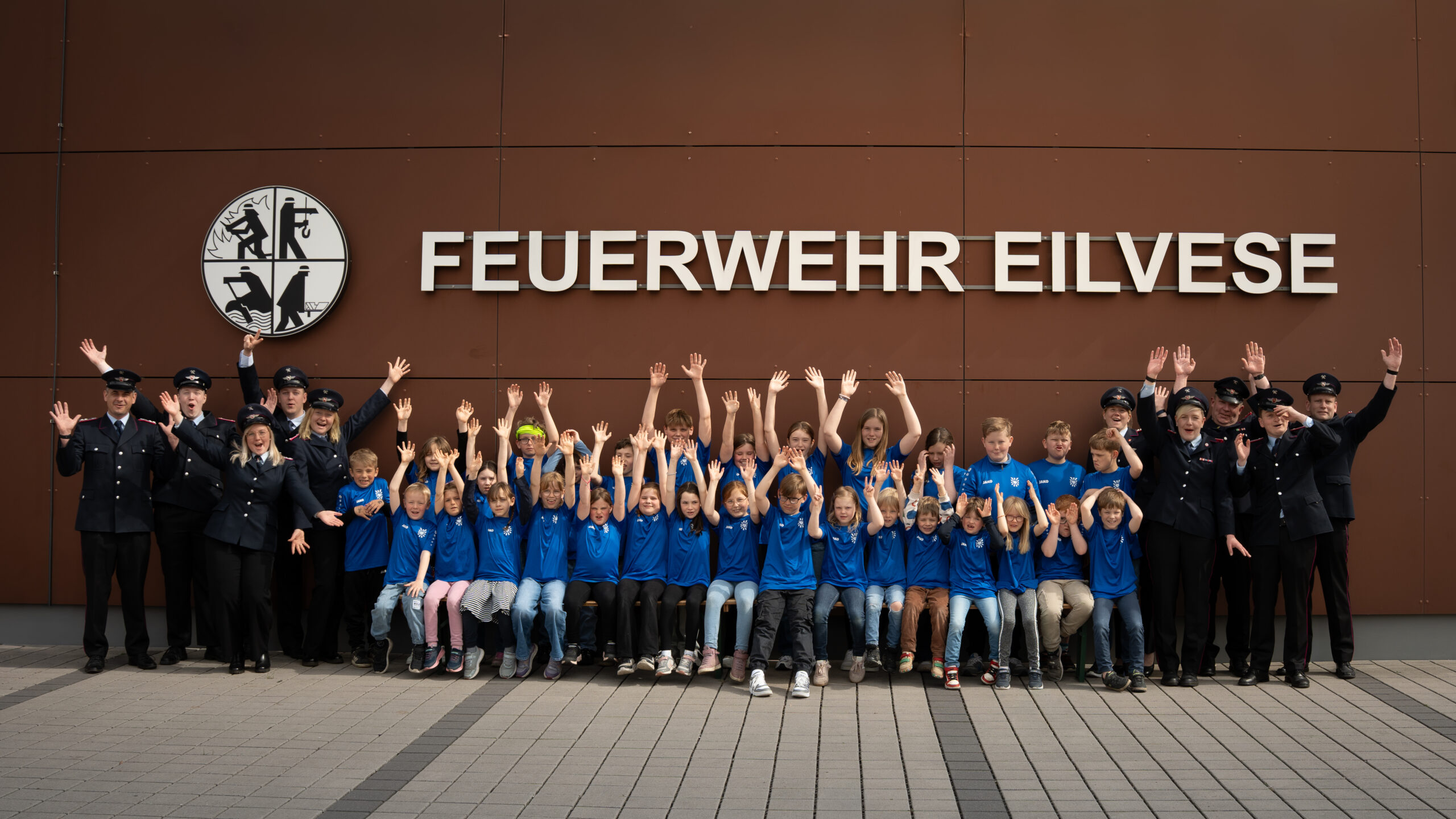 Die Kinderfeuerwehr Löschbande winkt beim Gruppenfoto