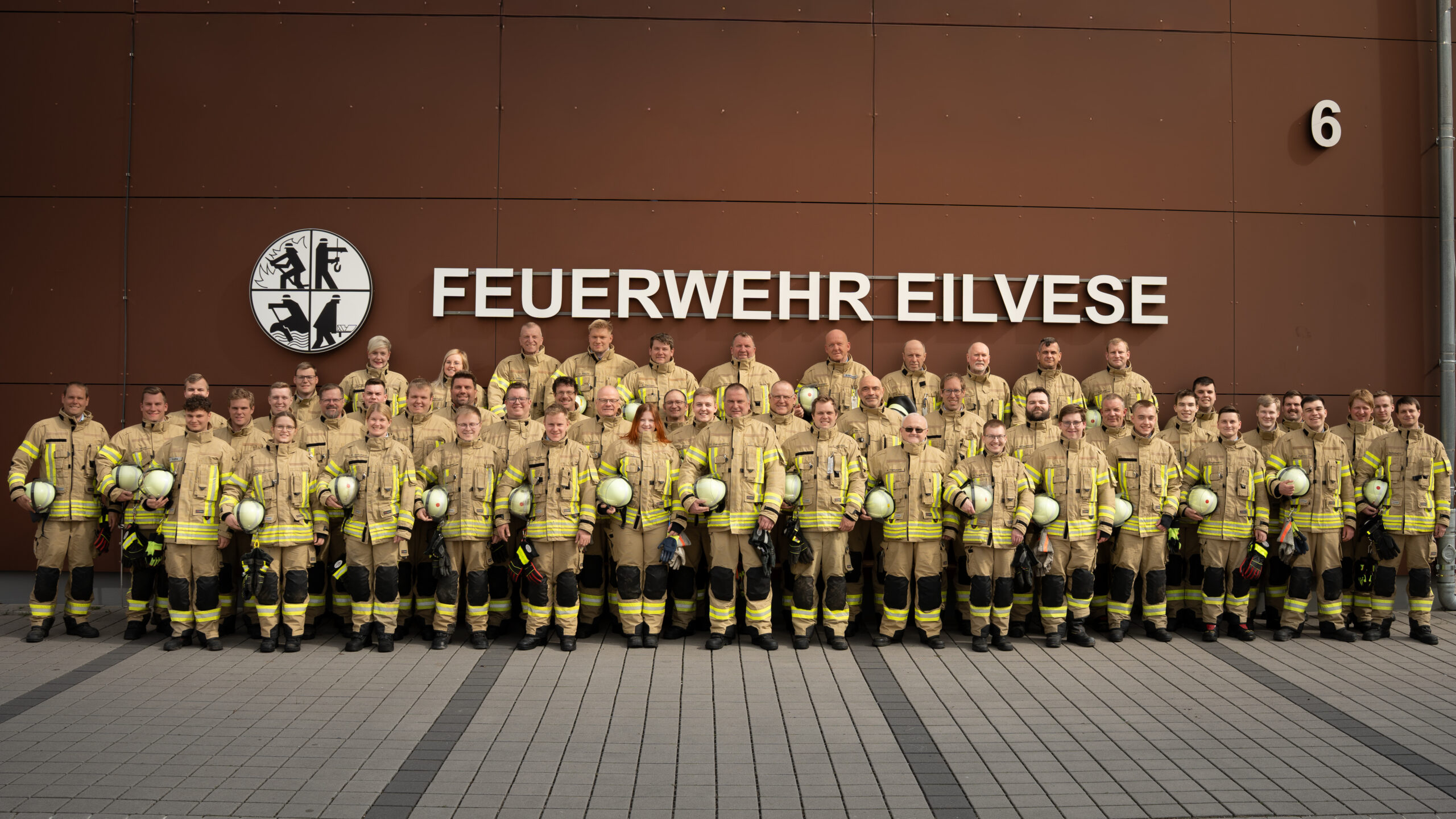 Gruppenfoto der Einsatzabteilung in Einsatzkleidung vor dem Feuerwehrhaus